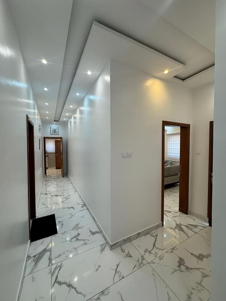 Gizli ışıklı alçı tavanlı, yeni boyanmış koridor